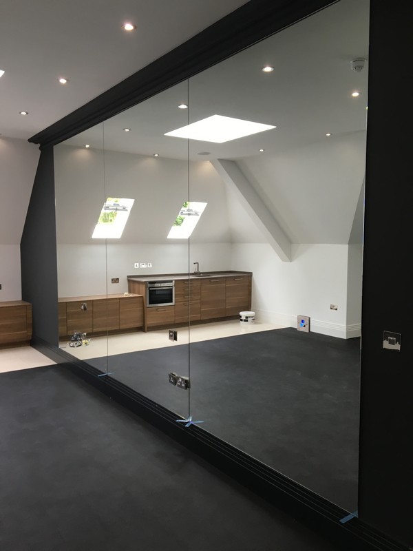 Frameless glass partition in loft conversion by Aldgate glaziers
